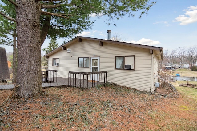 back of house featuring cooling unit and a wooden deck