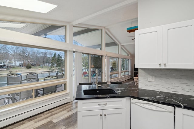 kitchen with a baseboard radiator, white cabinetry, a sink, white dishwasher, and backsplash