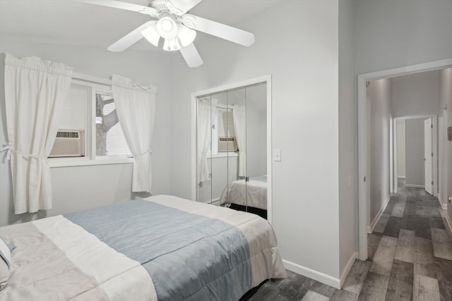 bedroom with cooling unit, baseboards, ceiling fan, a closet, and wood finished floors