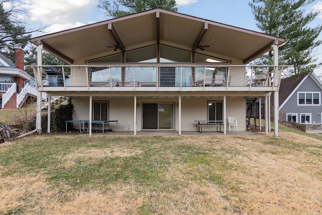 rear view of property featuring a wooden deck, a yard, and ceiling fan