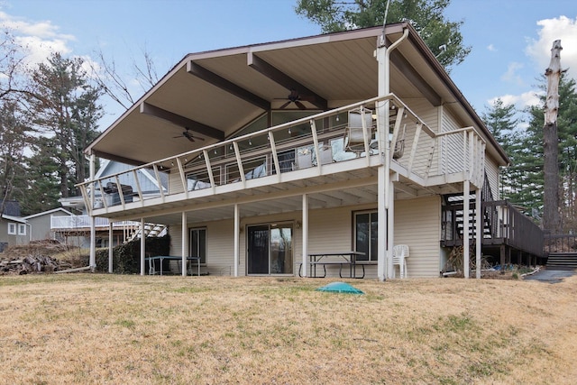 back of property with a lawn, a wooden deck, stairway, and a ceiling fan