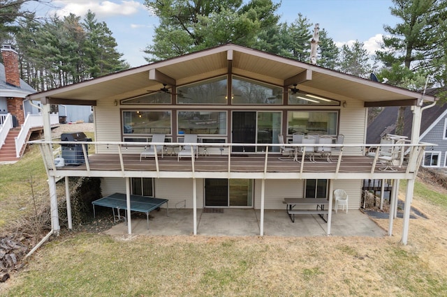 back of property with ceiling fan, a deck, and a patio area