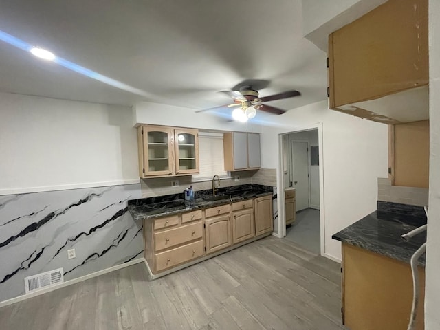 kitchen featuring a sink, glass insert cabinets, visible vents, light wood-style floors, and ceiling fan