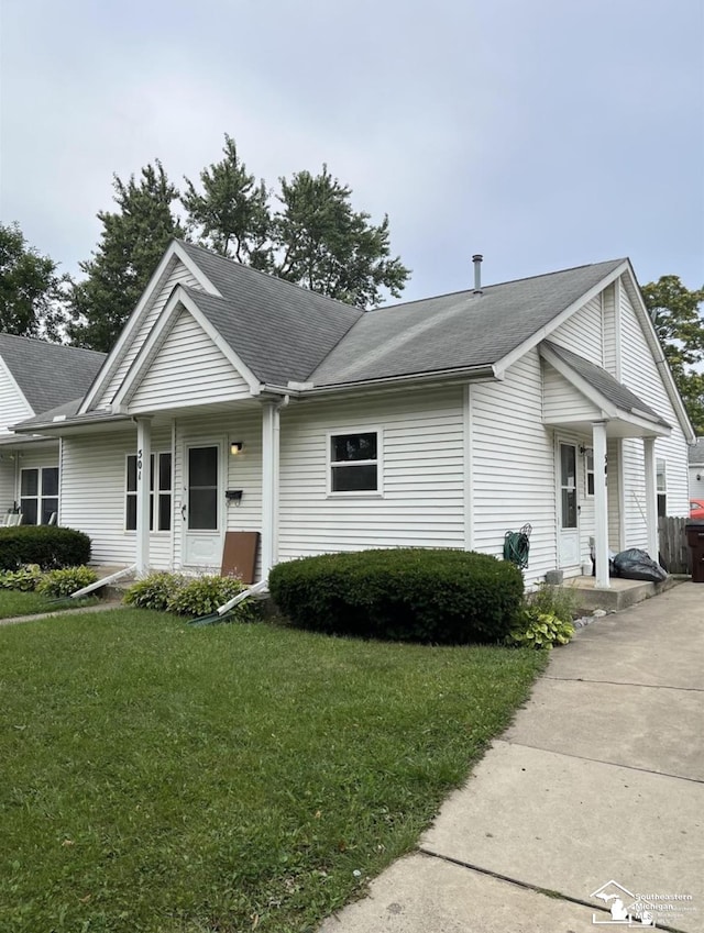 view of front of home featuring a front yard and roof with shingles