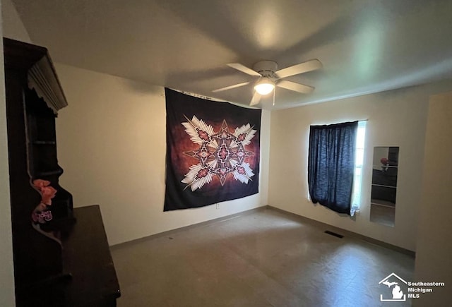 interior space with baseboards and ceiling fan
