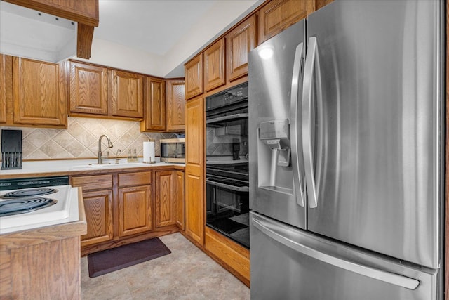 kitchen featuring decorative backsplash, brown cabinetry, stainless steel appliances, light countertops, and a sink