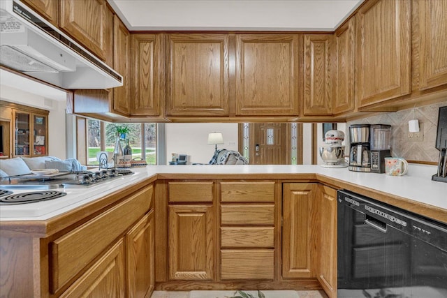 kitchen featuring brown cabinetry, dishwasher, under cabinet range hood, and light countertops
