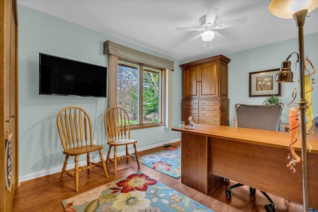 office area with wood finished floors, a ceiling fan, and baseboards