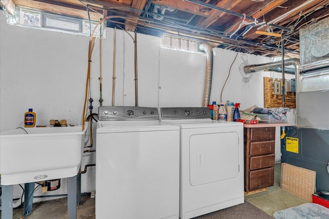 washroom featuring heating unit, a sink, laundry area, and washing machine and dryer