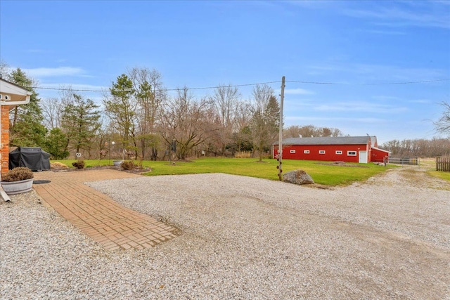 view of yard with gravel driveway and an outbuilding