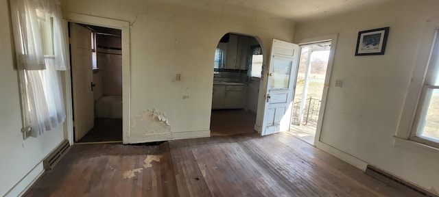 5640 Blue Star Hwy, South Haven, MI 49090 - unfurnished bedroom featuring hardwood / wood-style floors, arched walkways, and a baseboard heating unit