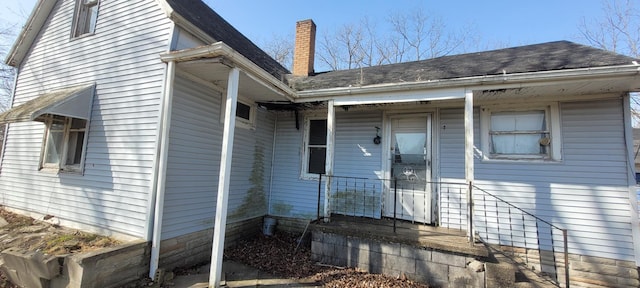 5640 Blue Star Hwy, South Haven, MI 49090 - property entrance featuring a chimney, a shingled roof, and a porch