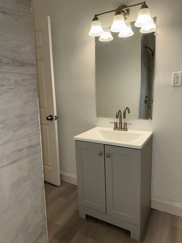 bathroom with wood finished floors, vanity, and baseboards