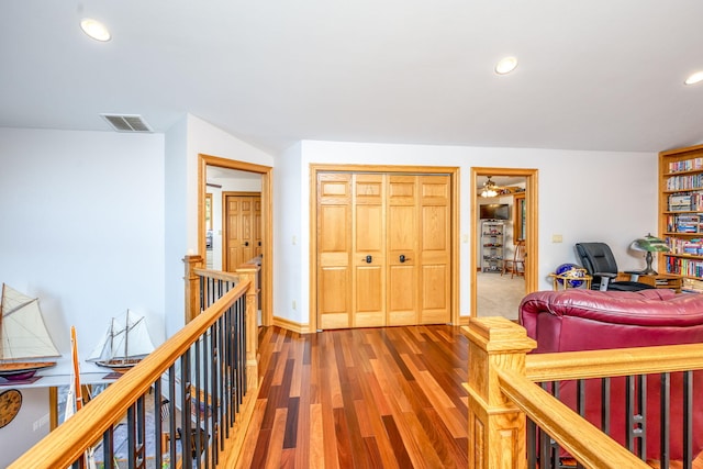 8366 Lynwood Ln, Mecosta, MI 49332 - hallway with an upstairs landing, wood finished floors, baseboards, visible vents, and recessed lighting