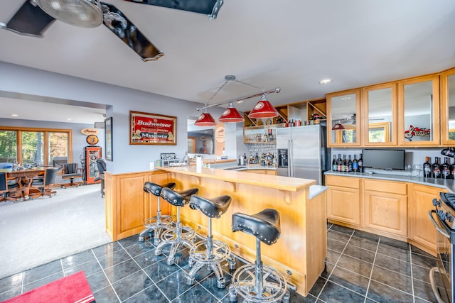 8366 Lynwood Ln, Mecosta, MI 49332 - kitchen with a breakfast bar area, appliances with stainless steel finishes, glass insert cabinets, dark colored carpet, and dark tile patterned floors