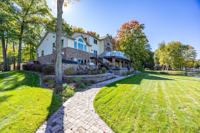 8366 Lynwood Ln, Mecosta, MI 49332 - rear view of house with a lawn, a deck, stone siding, and stairway