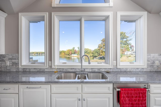 8366 Lynwood Ln, Mecosta, MI 49332 - kitchen with tasteful backsplash, vaulted ceiling, stainless steel dishwasher, a sink, and white cabinets