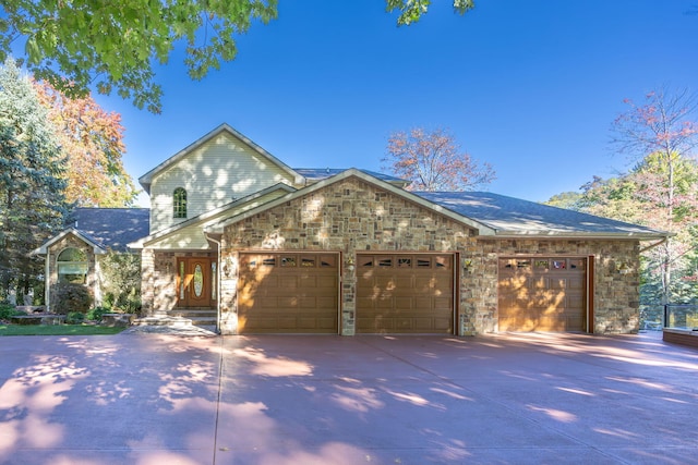 8366 Lynwood Ln, Mecosta, MI 49332 - view of front of property featuring driveway, stone siding, and a garage