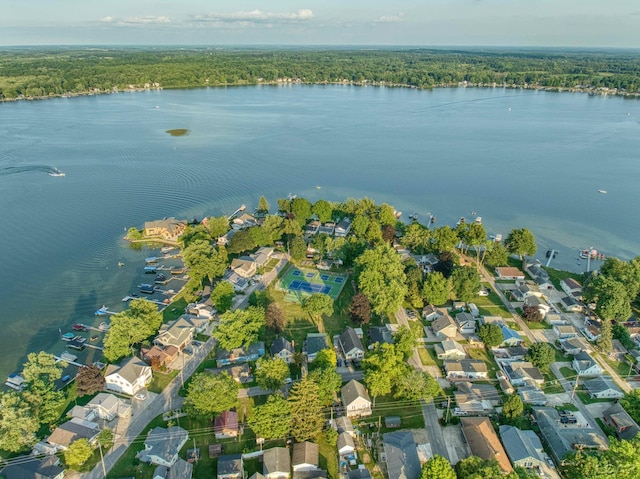 drone / aerial view with a residential view, a water view, and a forest view