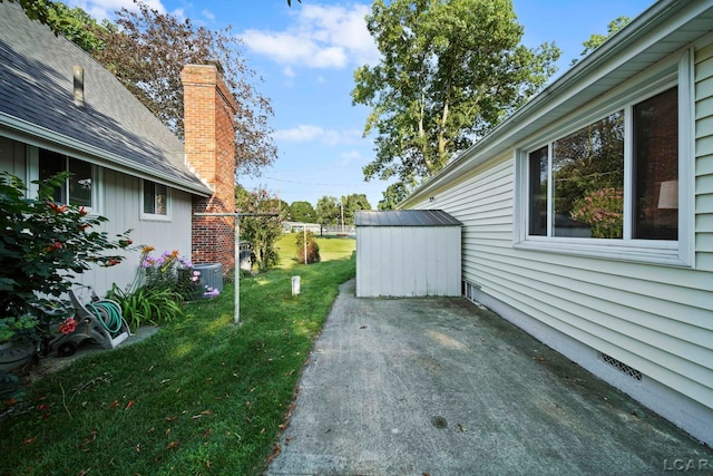 view of yard featuring central AC, an outdoor structure, a patio area, and a storage unit