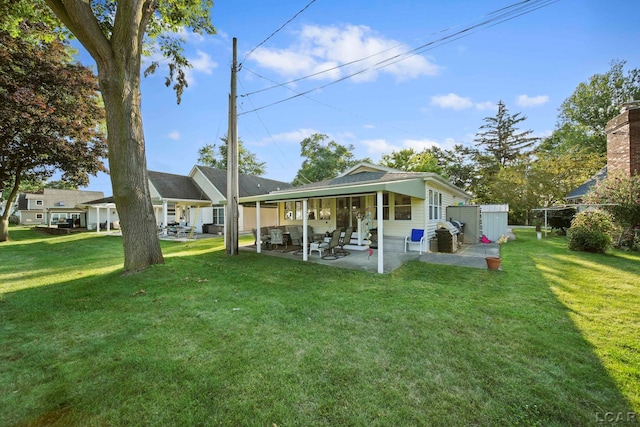 rear view of property featuring a lawn and a patio