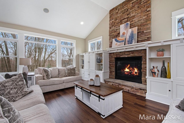 8821 Summerset Woods Ct SE, Alto, MI 49302 - living area featuring a stone fireplace, dark wood-type flooring, high vaulted ceiling, and recessed lighting