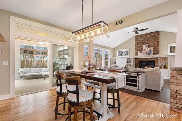 8821 Summerset Woods Ct SE, Alto, MI 49302 - dining room with vaulted ceiling, healthy amount of natural light, ceiling fan, wood finished floors, and a fireplace