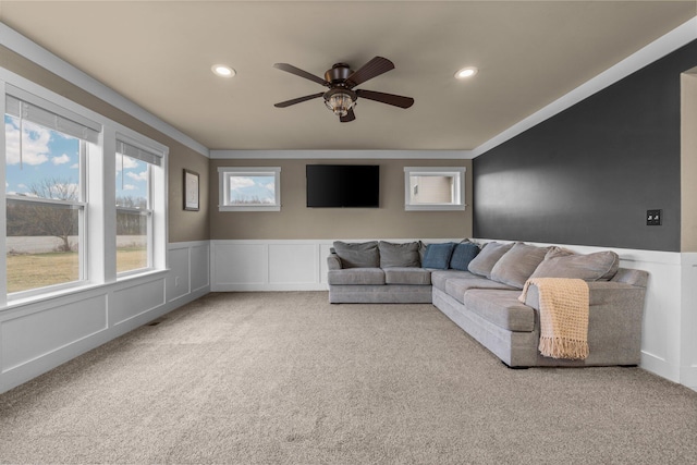 carpeted living area featuring a ceiling fan, a wainscoted wall, a decorative wall, and recessed lighting