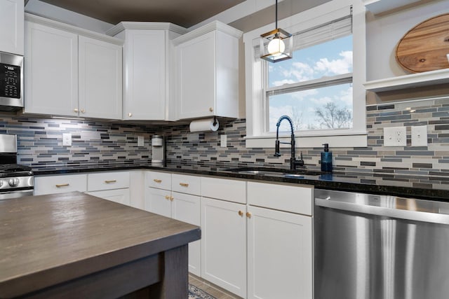 kitchen with white cabinets, a sink, tasteful backsplash, and appliances with stainless steel finishes