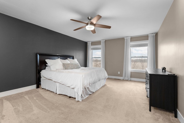 bedroom with baseboards, a ceiling fan, and light colored carpet