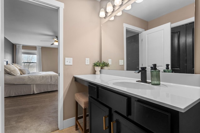 bathroom with a ceiling fan, vanity, baseboards, and ensuite bath