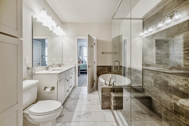 2667 Oxford Cir, Ann Arbor, MI 48103 - bathroom featuring marble finish floors, a shower stall, a garden tub, double vanity, and toilet