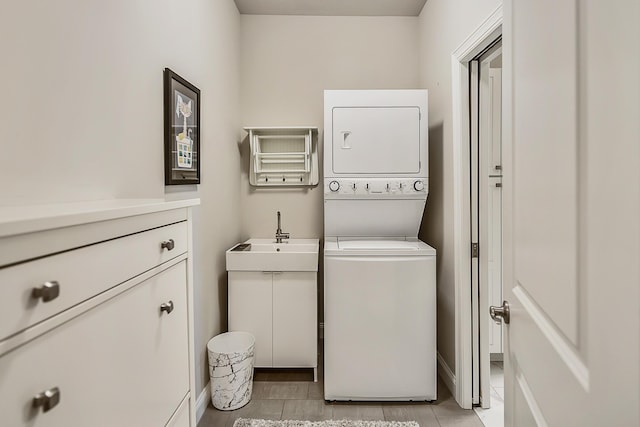 2667 Oxford Cir, Ann Arbor, MI 48103 - clothes washing area with stacked washer / dryer, cabinet space, baseboards, and light tile patterned floors