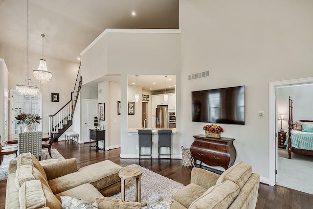 2667 Oxford Cir, Ann Arbor, MI 48103 - living room with a high ceiling, dark wood-style floors, stairs, a chandelier, and baseboards