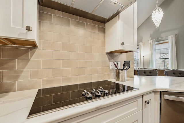 2667 Oxford Cir, Ann Arbor, MI 48103 - kitchen featuring stainless steel dishwasher, black electric cooktop, wall chimney exhaust hood, light countertops, and white cabinets