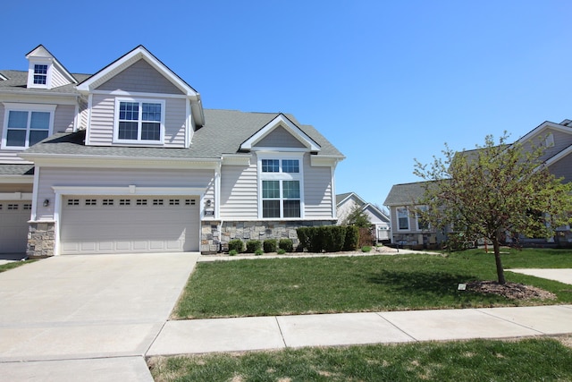 2667 Oxford Cir, Ann Arbor, MI 48103 - view of front of home featuring stone siding, a front lawn, a garage, and concrete driveway