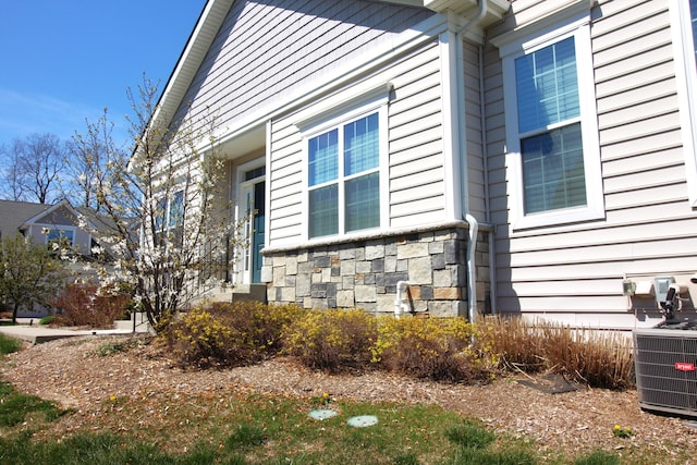 2667 Oxford Cir, Ann Arbor, MI 48103 - view of property exterior with stone siding and central AC
