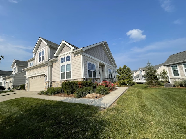 2667 Oxford Cir, Ann Arbor, MI 48103 - view of home's exterior with stone siding, concrete driveway, a garage, a yard, and cooling unit