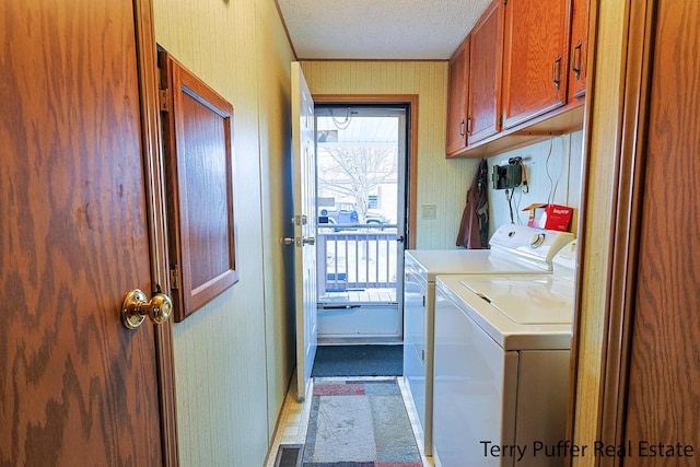 washroom with cabinet space, a textured ceiling, independent washer and dryer, and a wealth of natural light