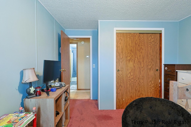 bedroom with a closet, a textured ceiling, and carpet