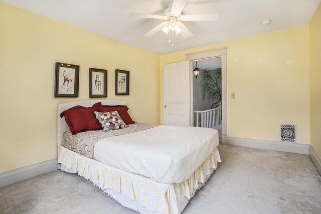 carpeted bedroom featuring baseboards, visible vents, and a ceiling fan