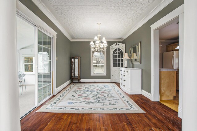 unfurnished dining area featuring an ornate ceiling, a chandelier, baseboards, ornamental molding, and a healthy amount of sunlight