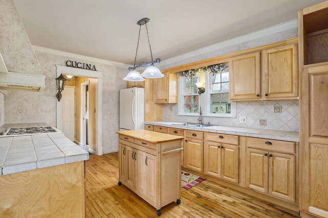 kitchen featuring white appliances, ornamental molding, light brown cabinets, tile countertops, and a sink