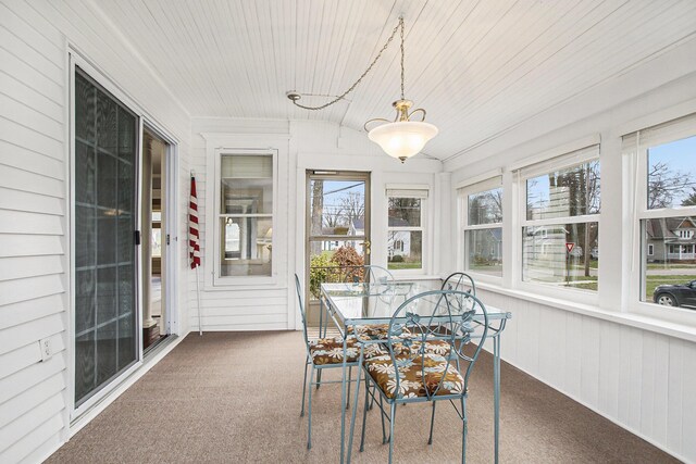 sunroom with carpet floors, a wealth of natural light, and wood ceiling
