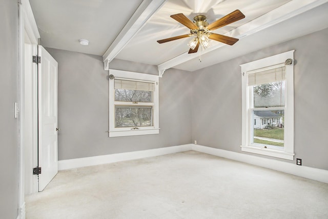 spare room with light carpet, baseboards, and beam ceiling