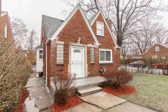 11135 Courville St, Detroit, MI 48224 - view of front of house with brick siding, a shingled roof, fence, and a chimney