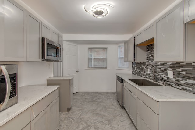 11135 Courville St, Detroit, MI 48224 - kitchen with gray cabinets, light stone counters, a sink, appliances with stainless steel finishes, and decorative backsplash