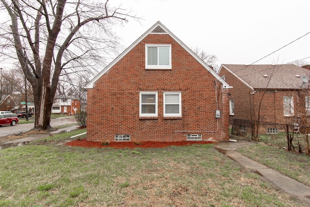 11135 Courville St, Detroit, MI 48224 - view of home's exterior featuring a lawn, brick siding, and fence