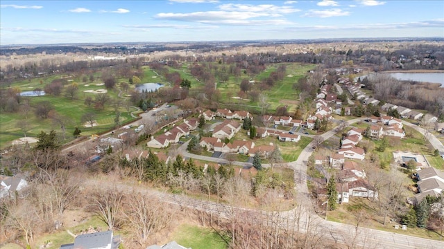 aerial view of property and surrounding area featuring a large body of water, nearby suburban area, and a golf course
