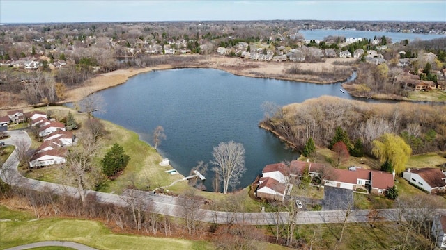 aerial view of property and surrounding area with a large body of water and nearby suburban area